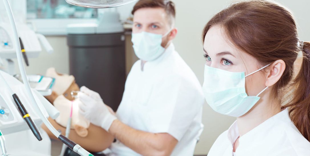 Two dental students listen attentively