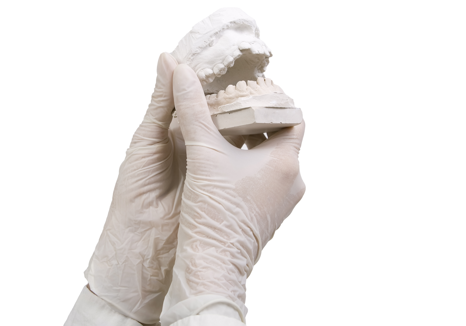 Dental technician holding a ceramic tooth replica in his hand.